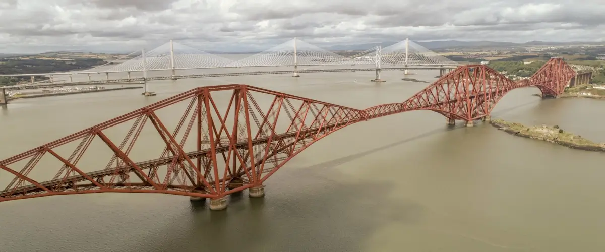 Aerial view of the Forth Bridge with the Queensferry Crossing behind it, overlooking the Firth of Forth near South Queensferry, Edinburgh.