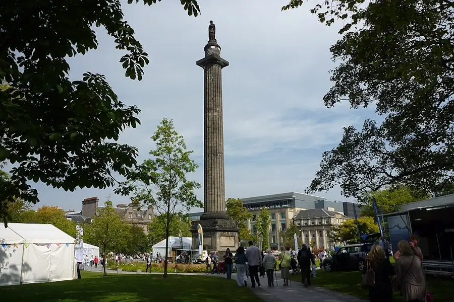 Melville Monument in St Andrew Square, Edinburgh, with people walking through the square and surrounding New Town buildings visible