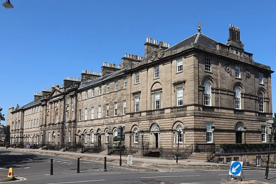 Georgian terrace at Charlotte Square in Edinburgh’s New Town, showing Bute House and surrounding stone townhouses with iron railings along the street.