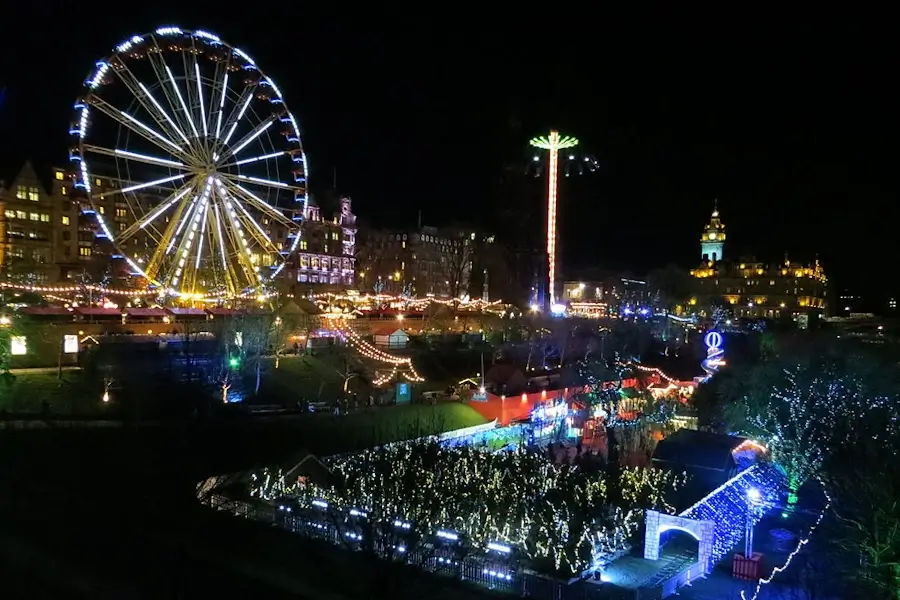 princess street in december with christmas markets and fairground attractions
