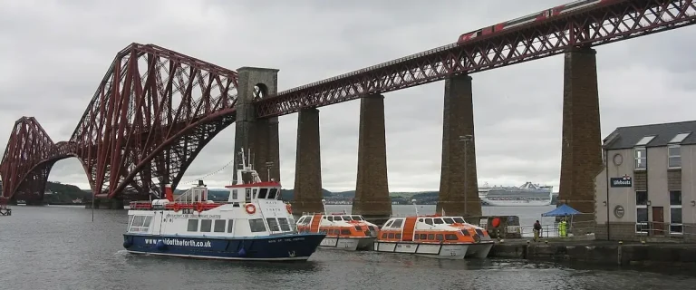 Hawes Pier at South Queensferry with cruise tender boats and the Forth Bridge overhead