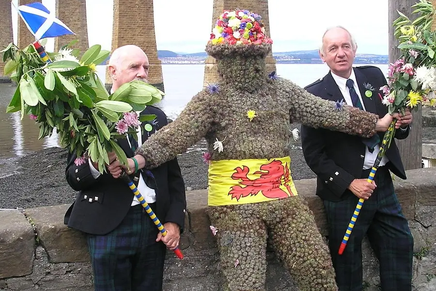 Queensferry tradition the burry man during the ferry fair picutred under the forth bridge