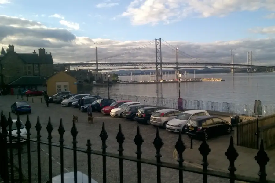 photograph of forth road bridge and queensferry crossing over grey waters taken from mid-terrace