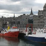 Aberdeen cruise port docked ships at harbour with city skyline in background