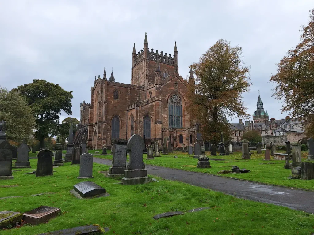 Dunfermline Abbey church tower and nave behind the graveyard in autumn