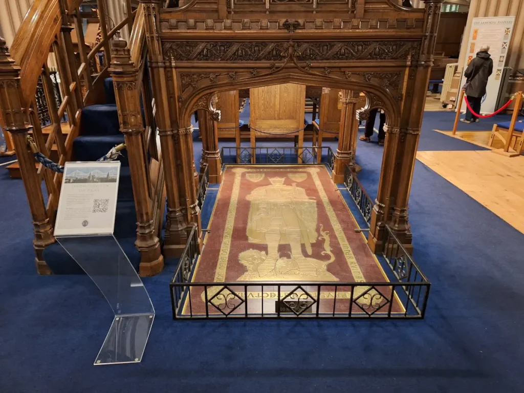 Robert the Bruce’s grave in Dunfermline Abbey, with the brass memorial before the pulpit and an information sign